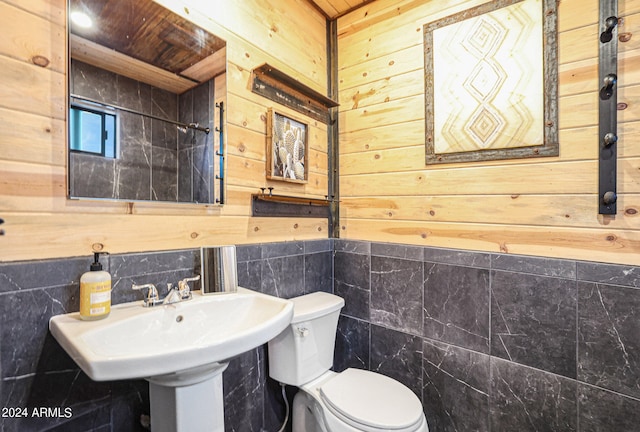 bathroom featuring wood walls, tile walls, toilet, and backsplash