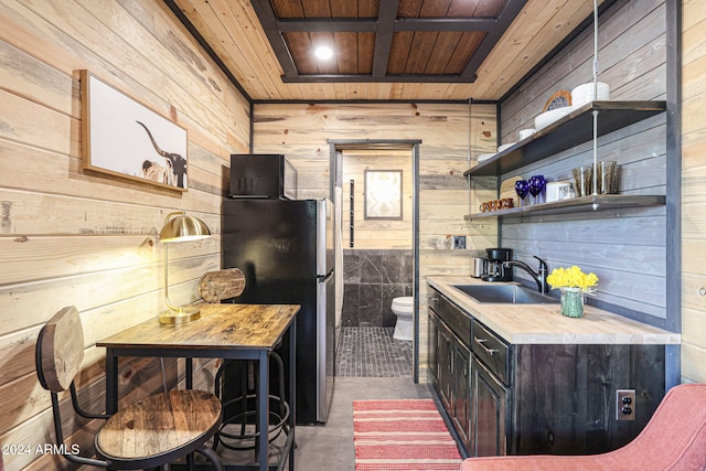 kitchen featuring sink, wooden walls, and wooden ceiling