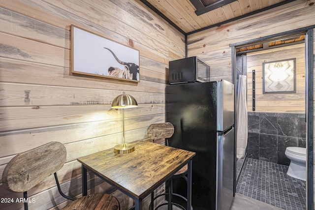 interior space with wood walls, stainless steel refrigerator, and wooden ceiling