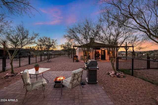 patio terrace at dusk featuring a fire pit