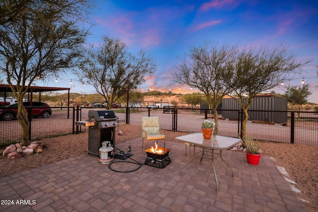 patio terrace at dusk featuring an outdoor fire pit