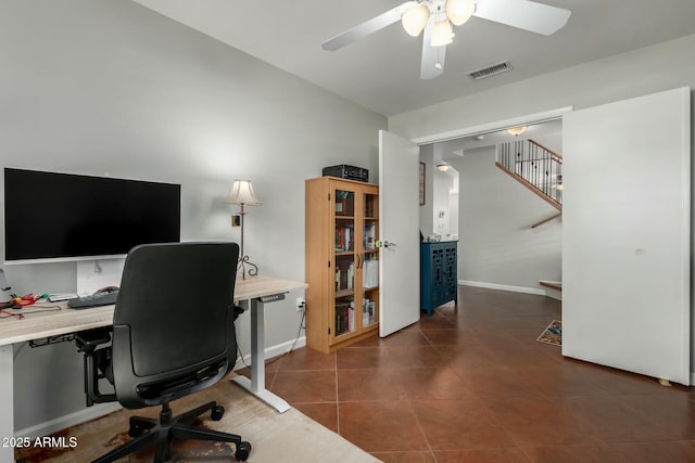 tiled office space featuring visible vents, ceiling fan, and baseboards