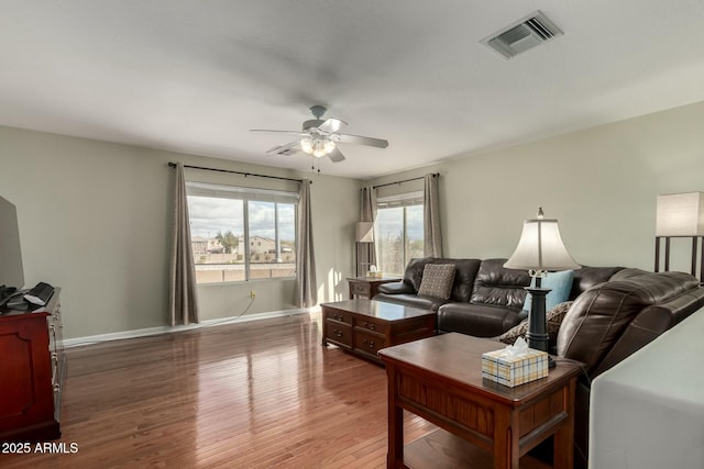 living room with a ceiling fan, baseboards, visible vents, and wood finished floors