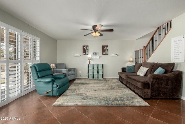 living room featuring ceiling fan, baseboards, and dark tile patterned flooring