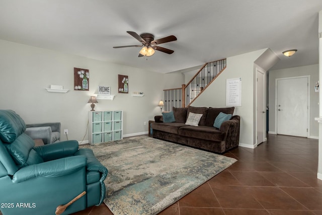 living area with dark tile patterned flooring, ceiling fan, stairway, and baseboards