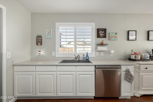 kitchen with dishwasher, light countertops, a sink, and white cabinetry