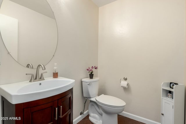 bathroom with baseboards, vanity, and toilet