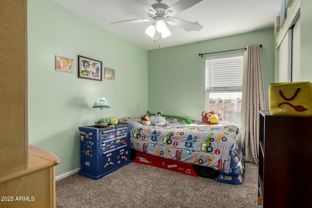 carpeted bedroom with ceiling fan and baseboards