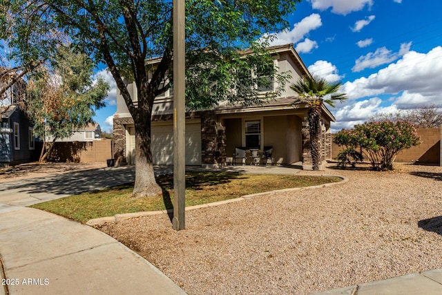 view of front of house featuring driveway, a garage, fence, and stucco siding