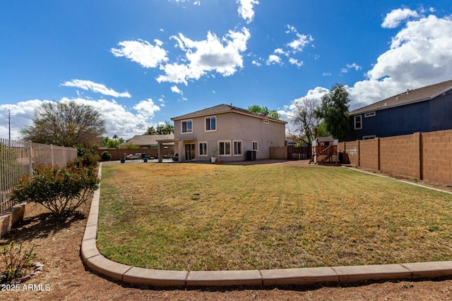 back of house with a yard, a patio, a fenced backyard, and stucco siding