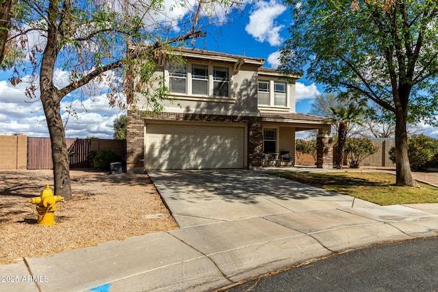 traditional-style home with brick siding, stucco siding, concrete driveway, an attached garage, and fence