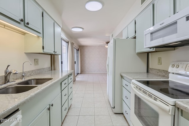 kitchen with white appliances, light tile patterned flooring, sink, and ceiling fan