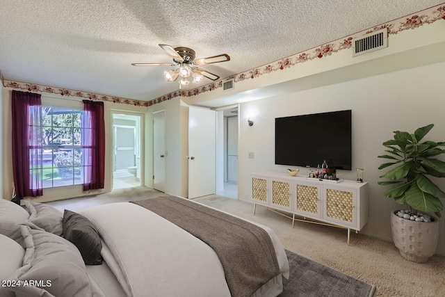 bedroom with ceiling fan, a textured ceiling, light carpet, and ensuite bathroom