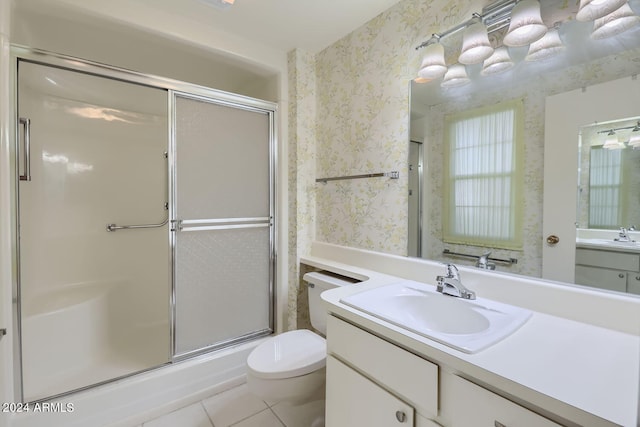 bathroom featuring tile patterned flooring, walk in shower, vanity, and toilet