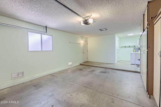 garage featuring visible vents, baseboards, and a garage door opener