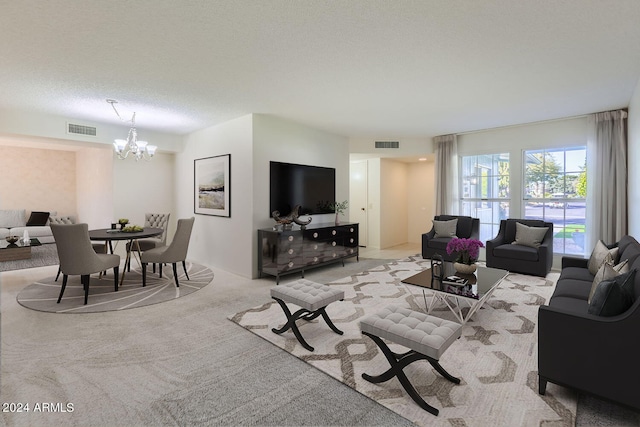 carpeted living room with a notable chandelier and a textured ceiling