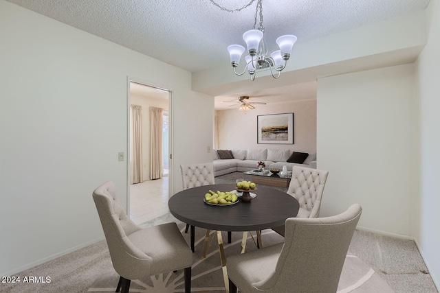 dining space featuring light colored carpet, a textured ceiling, and an inviting chandelier