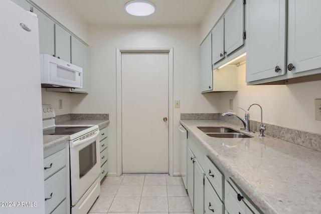 kitchen featuring a sink, light tile patterned floors, light countertops, and white appliances