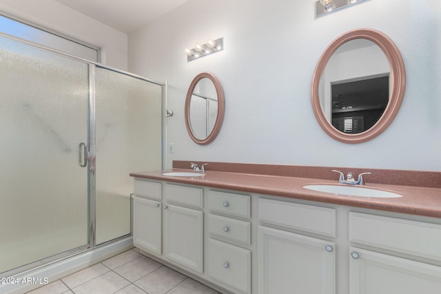 bathroom featuring tile patterned flooring, a shower with shower door, and vanity