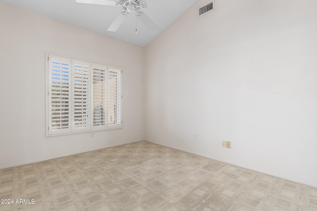 carpeted empty room featuring ceiling fan and vaulted ceiling