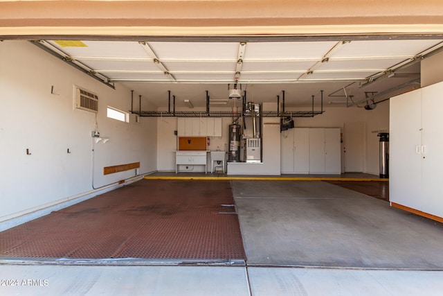 garage with gas water heater and an AC wall unit