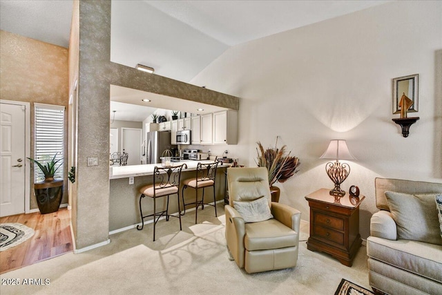 living room with light colored carpet, baseboards, and high vaulted ceiling
