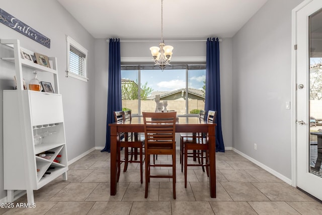 dining room featuring a notable chandelier, light tile patterned flooring, and baseboards