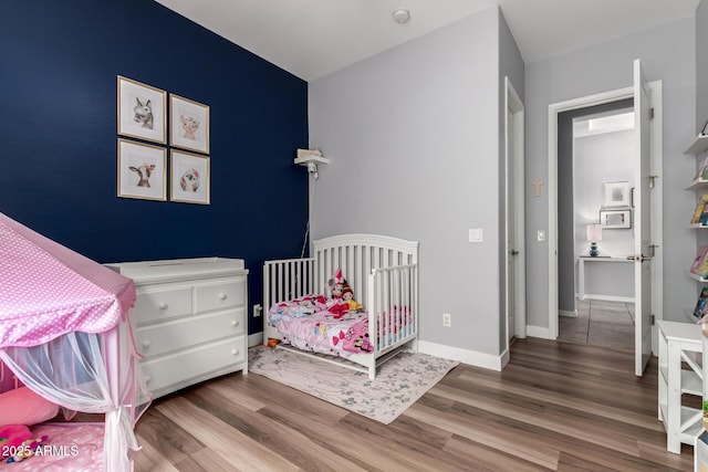 bedroom featuring wood finished floors and baseboards