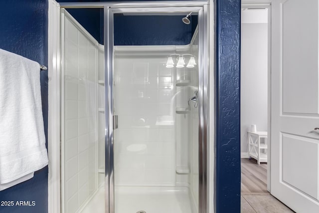 bathroom featuring a shower stall and a textured wall