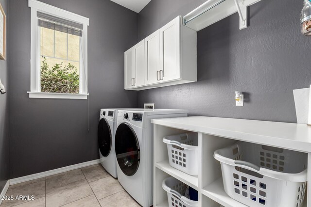 laundry area with baseboards, cabinet space, separate washer and dryer, and light tile patterned flooring