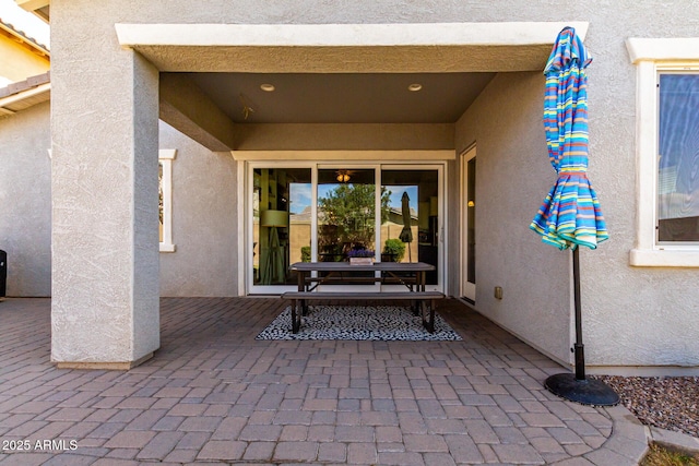 entrance to property with a patio and stucco siding