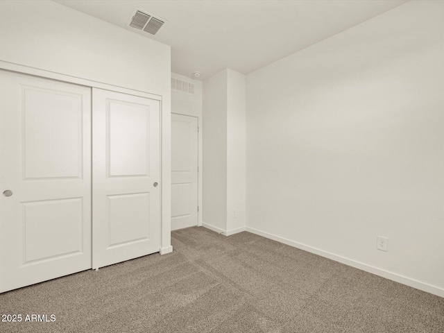 unfurnished bedroom with baseboards, a closet, visible vents, and carpet flooring