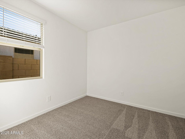 unfurnished room with carpet flooring and baseboards