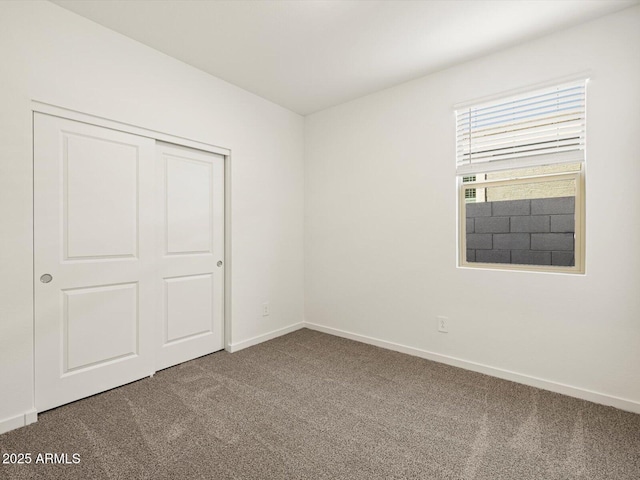 unfurnished bedroom featuring carpet floors, a closet, and baseboards