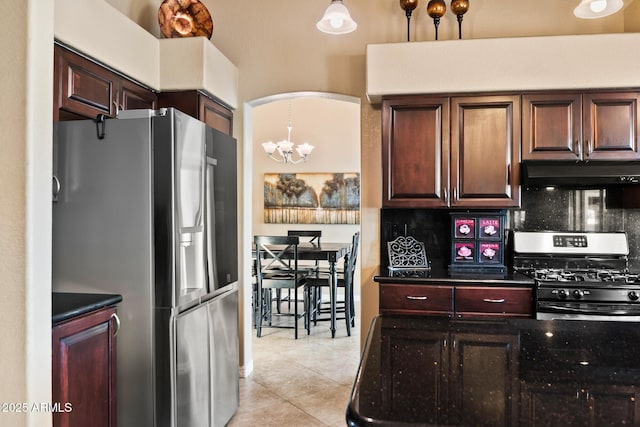 20657 N 56th Ave, Glendale, AZ 85308 - kitchen featuring appliances with stainless steel finishes, under cabinet range hood, backsplash, light tile patterned floors, and a chandelier