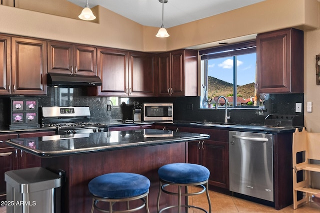 20657 N 56th Ave, Glendale, AZ 85308 - kitchen with appliances with stainless steel finishes, under cabinet range hood, a center island, a kitchen bar, and backsplash