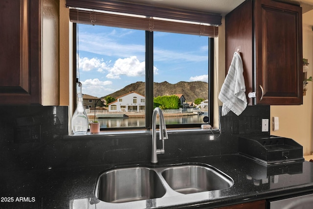 20657 N 56th Ave, Glendale, AZ 85308 - kitchen featuring backsplash, a water and mountain view, dark brown cabinetry, dark stone countertops, and a residential view