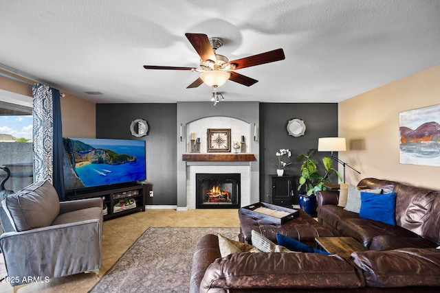 20657 N 56th Ave, Glendale, AZ 85308 - tiled living room featuring a warm lit fireplace, a ceiling fan, and a textured ceiling