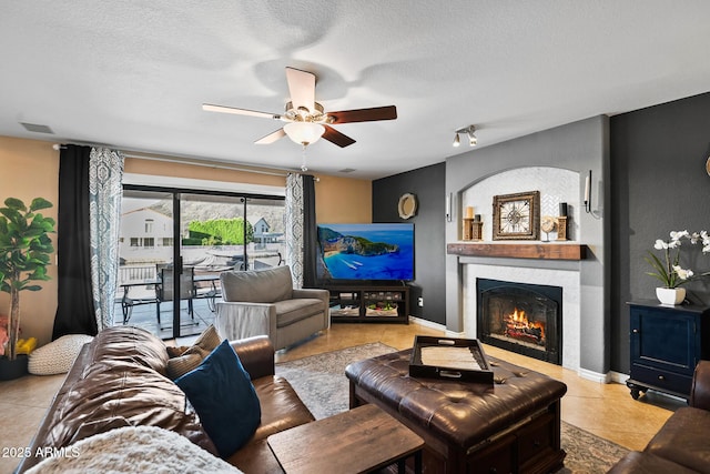 20657 N 56th Ave, Glendale, AZ 85308 - living area with a ceiling fan, a warm lit fireplace, and a textured ceiling