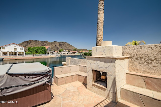 20657 N 56th Ave, Glendale, AZ 85308 - view of patio featuring an outdoor stone fireplace, a mountain view, and a hot tub