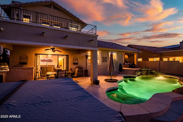 20657 N 56th Ave, Glendale, AZ 85308 - pool at dusk featuring an outdoor kitchen, a patio, ceiling fan, a fenced backyard, and outdoor lounge area