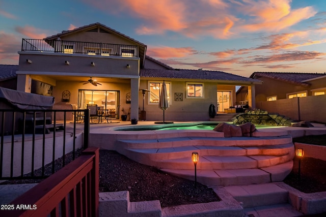 20657 N 56th Ave, Glendale, AZ 85308 - rear view of house with an in-ground hot tub, a balcony, ceiling fan, stucco siding, and a patio area