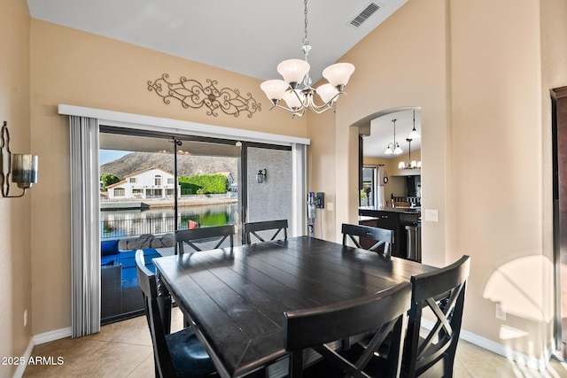 20657 N 56th Ave, Glendale, AZ 85308 - dining area featuring a chandelier, light tile patterned flooring, arched walkways, a water view, and high vaulted ceiling