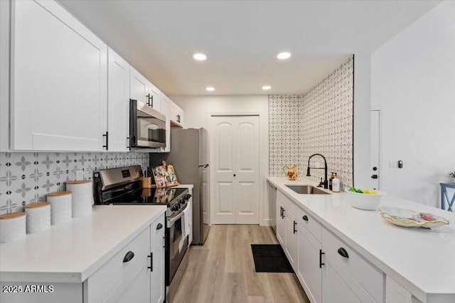 623 W Guadalupe Rd Unit 288, Mesa, AZ 85210 - kitchen with appliances with stainless steel finishes, a sink, a peninsula, light wood finished floors, and tasteful backsplash