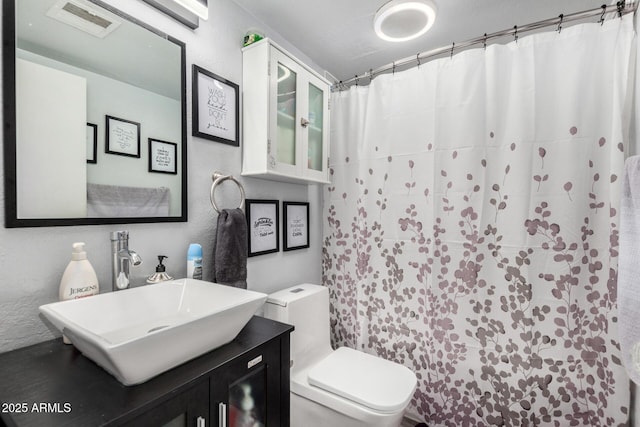 bathroom with toilet, vanity, and a shower with shower curtain