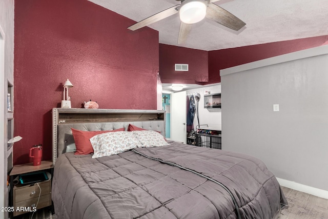 bedroom with ceiling fan, wood-type flooring, and lofted ceiling