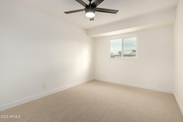 empty room with a ceiling fan, light colored carpet, and baseboards