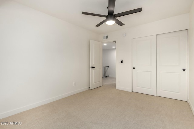 unfurnished bedroom featuring a closet, visible vents, light carpet, ceiling fan, and baseboards