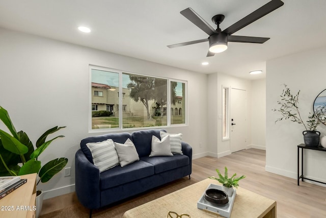 living area with a ceiling fan, recessed lighting, light wood-style flooring, and baseboards