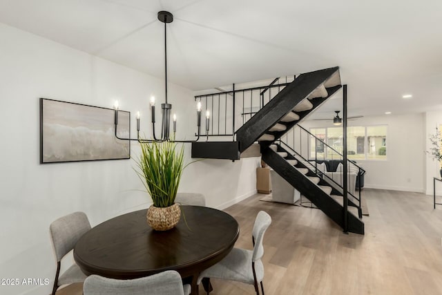 dining room with stairs, wood finished floors, and baseboards